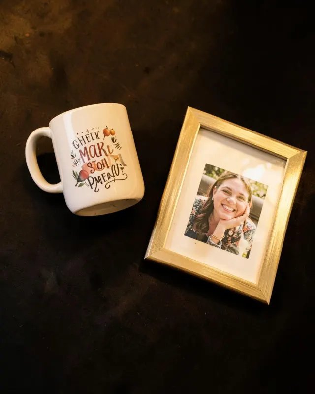 Printed photo mug and a gold photo frame on a dark surface